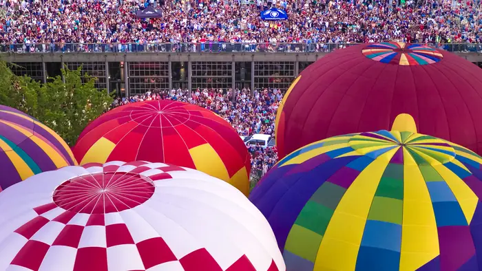 Aerial view of hot air balloon tops with the crowd lining the terrace at Seattle Center