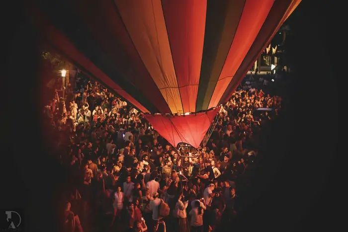 Spectators gathered beneath a glowing hot air balloon at Seattle Center